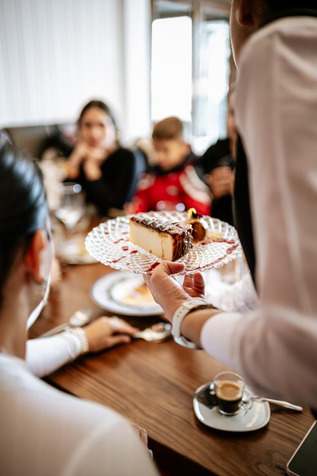 Camarero sirviendo un postre a un grupo de comensales