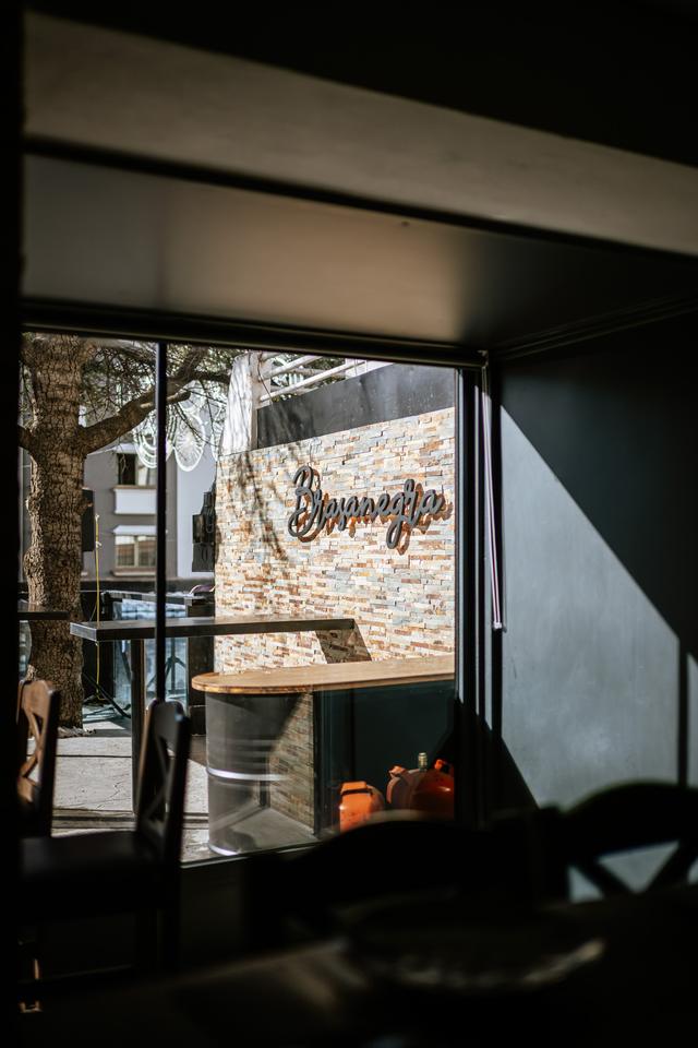 Entrada del restaurante con el logotipo de Brasanegra sobre piedra