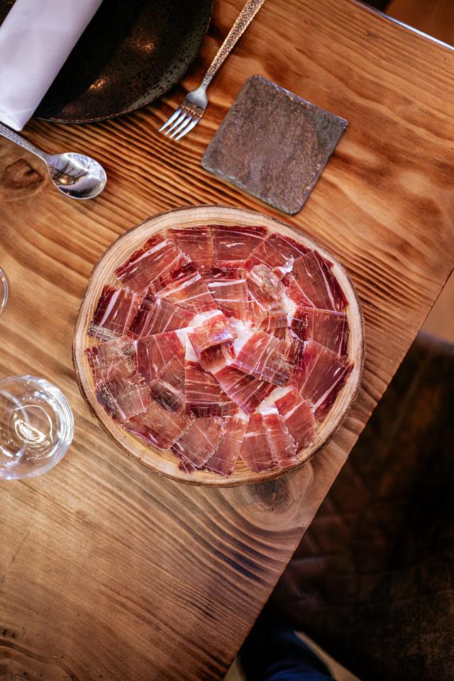 Plato de jamón cortado sobre tabla de madera